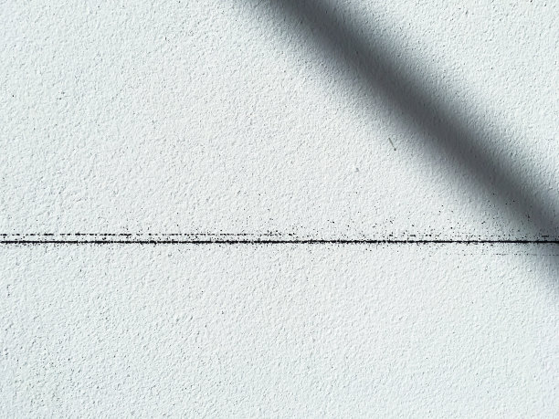 一个黑色的线条在未加工的混凝土或裸露的水泥墙面纹理，抽象的白色背景，光影图片下载