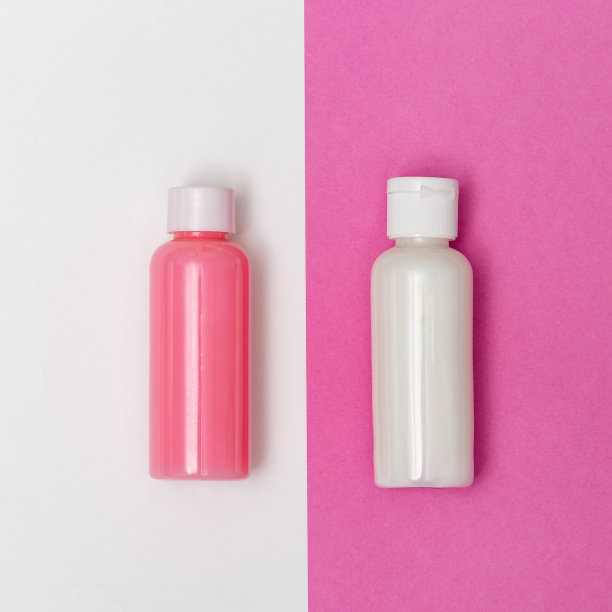 平面铺设组成与化妆品。白色和粉红色的瓶子在彩色纸背景模拟。妇女美容卫生用品。前视图。图片下载