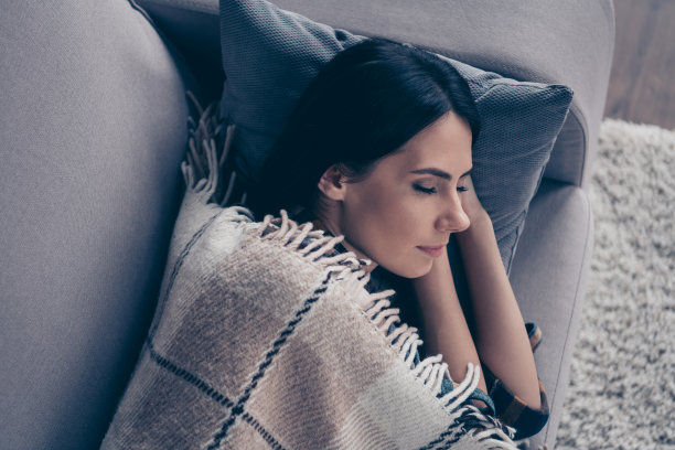 近看上面，在高角度照片美丽的她，她的夫人睡着了，手，胳膊，在头下做梦覆盖的毯子，穿格子格子衬衫躺在舒适的沙发公寓客厅室内图片下载