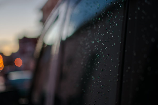 雨点落在一辆黑色汽车的侧面后窗上图片下载