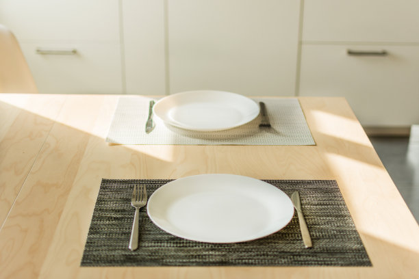 厨房内部的木桌上放着空盘子和刀叉。图片下载
