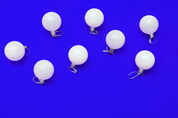 蓝色纸背景上的新年玻璃球。节日快乐圣诞概念。明亮的圣诞贺卡。前视图。平的。图片下载