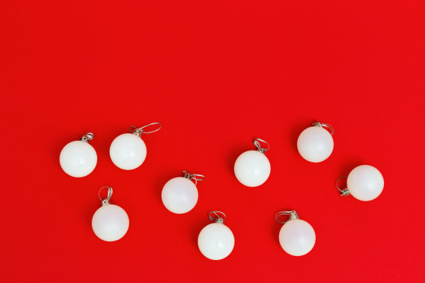 圣诞装饰，同样的白色球靠近红色背景与复制空间。新年和寒假的概念。平的。前视图。图片下载
