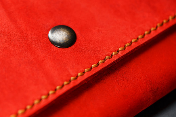 红色皮革钱包在一个黑暗的背景俯视图。特写，钱包细节，铆钉和固件图片下载