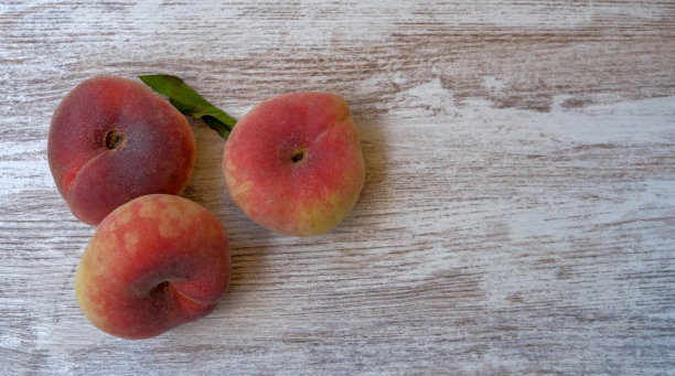 俯视图上成熟多汁的土星桃子在一个木制的背景。图片下载