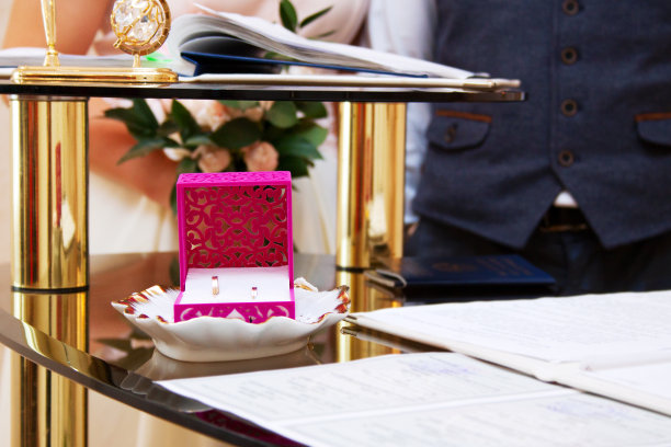 结婚仪式上，新婚夫妇在背景中可见，集中在戒指上图片下载