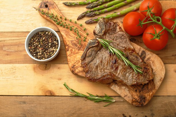 大理石牛排板上的迷迭香、胡椒、香料和新鲜蔬菜在一个木制的背景，餐厅菜单，美食，美味的食物。水平的照片,横幅图片下载