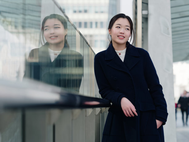 美丽的中国女孩和她镜中的形象，黑色的长发，微笑和快乐的年轻亚洲女人的肖像。图片下载