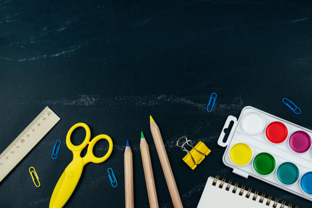 不同的学习用品在黑板的背景上。图片下载