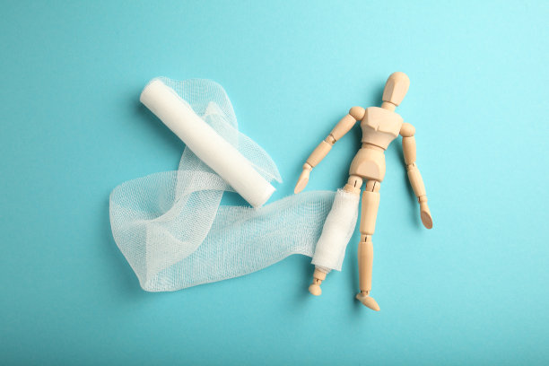 腿部受伤的男子的身影，用白色纱布包扎。急救，伤害治疗。病人在医院图片下载