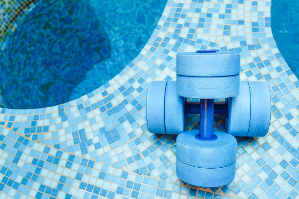 游泳池附近的水中有氧运动用哑铃设备图片下载