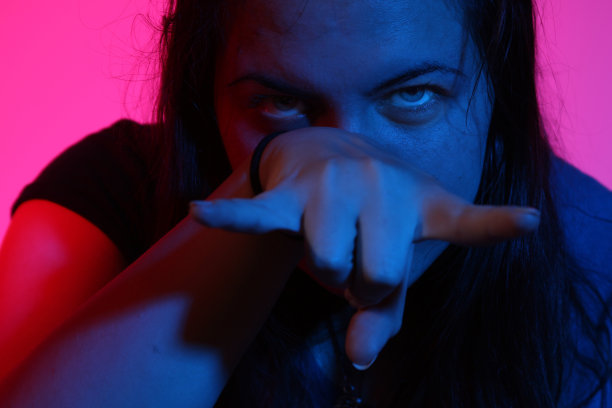 年轻女子的脸被涂上了紫色和蓝色的光，仔细看图片下载