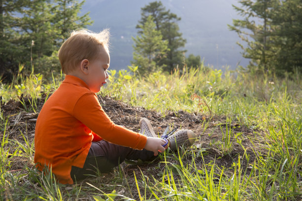 草地森林里的小男孩在玩剪刀图片下载