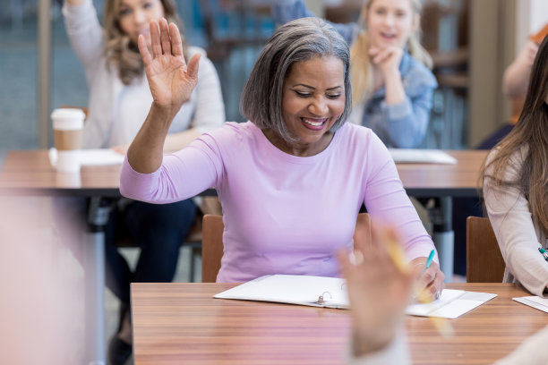 成熟的女大学生在课堂上举手图片下载