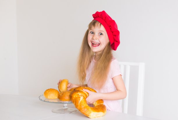 小女孩的脸，红帽子，烤面包，特写图片下载