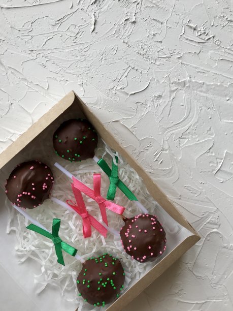 蛋糕棒棒糖装饰蝴蝶结，包装在礼品盒。表面覆盖着白色的装饰石膏。图片下载