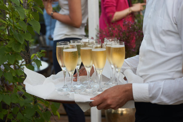 在婚礼宴会上，侍者端来了一盘香槟，特写图片下载