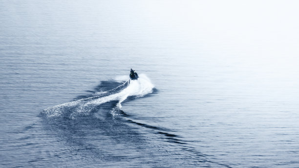 水上自行车在湖面上形成一个弯曲的尾巴图片下载