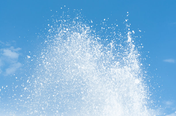 凉爽和新鲜的水溅在清澈的蓝天背景。图片下载