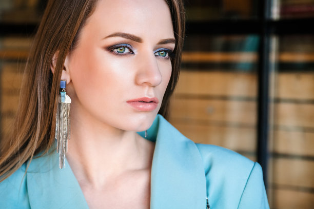 年轻美丽的金发女孩绿色的眼睛和丰满的嘴唇看着镜头，脸部特写。在街上拍的照片。皮肤修整图片下载