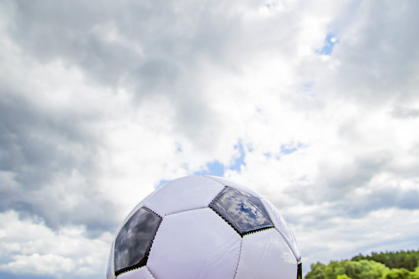 足球在多云的天空背景。图片下载