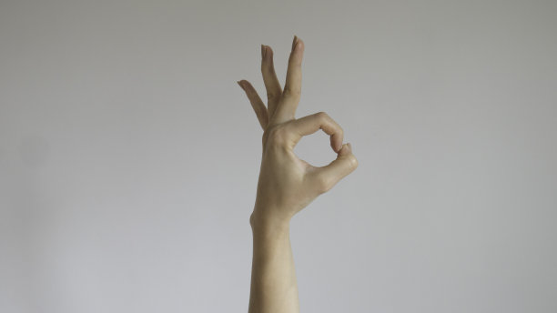 女人在一个白色孤立的背景上举手OK图片下载