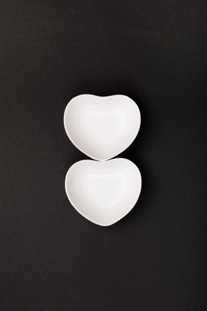 黑色背景上的心型白色餐具。俯视图图片下载