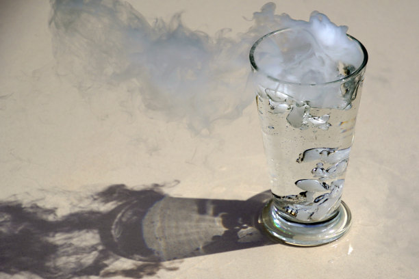 杯子里的云。暴风骤雨。白色的透明玻璃。水和蒸汽。图片下载