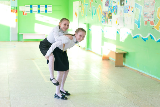 一个女学生把妹妹背在背上。图片下载