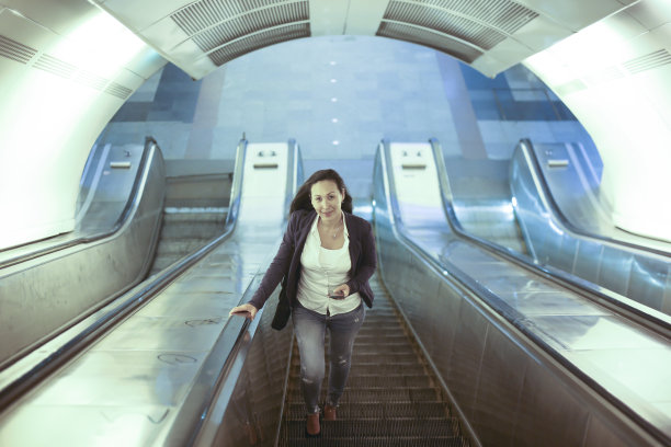 一个上自动扶梯的亚洲女人图片下载