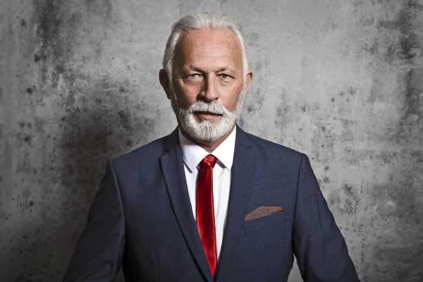 成熟的商人靠着混凝土墙图片下载