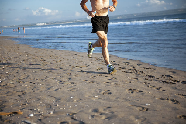 健康的男性在海滩上慢跑图片下载