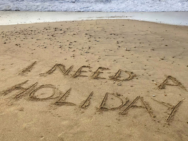 图片写在阳光明媚的海滩上，我需要假期的单词写在沙子上，用木棍，海浪，概念社交媒体照片的手写字母在柔软的金色沙滩上，多塞特，英国海边的海岸线图片下载