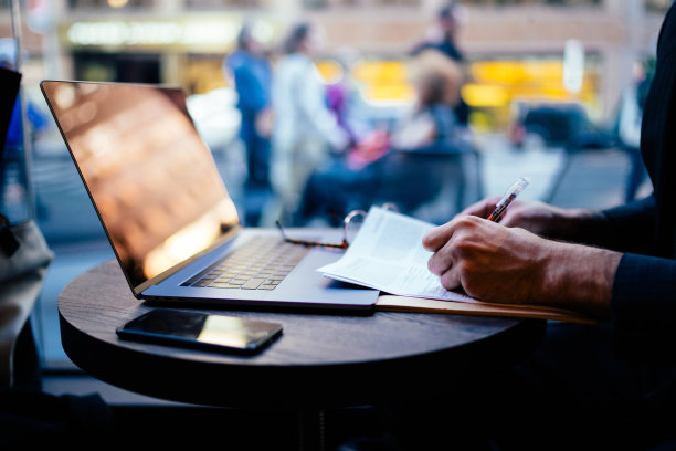 图片是manâ的手规划策略，在纸上做笔记，在咖啡馆内部使用wifi和笔记本电脑远程工作，男性律师检查文件和编辑文本在空闲时间图片下载