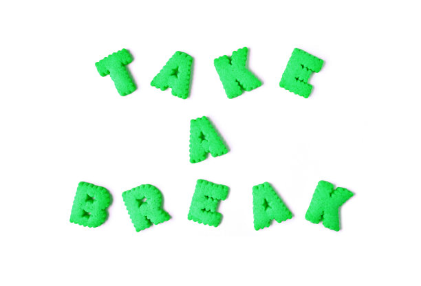 单词TAKE IT EASY的拼写与石灰绿色字母形状饼干在白色的背景图片下载