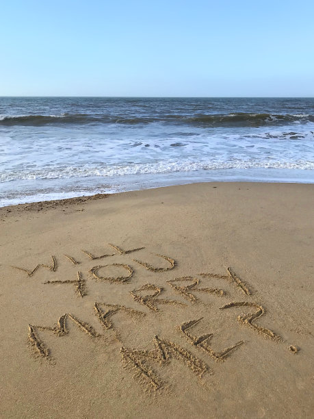 在阳光明媚的海滩上写的“你愿意嫁给我吗”，用木棍在沙子上写的问号字，海浪，概念社交媒体上的照片，在英国多塞特郡伯恩茅斯海滩柔软的金色沙滩上手写的字母图片下载