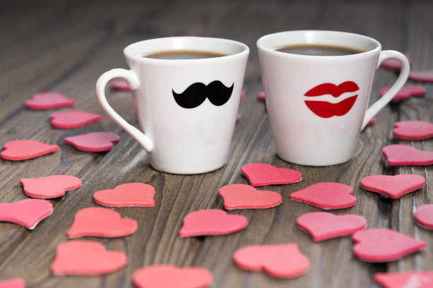 两个咖啡杯，木制背景上的心形图案。图片下载