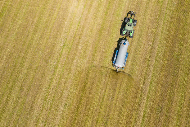 农用拖拉机在田间耕作和喷洒的鸟瞰图。农业。从以上观点。无人机拍摄的照片。图片下载