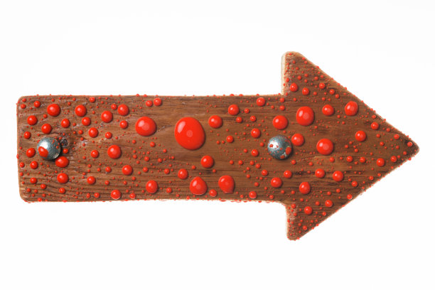 美丽的彩色水滴在一个木制路标与铁螺栓。红色的油漆滴。图片下载