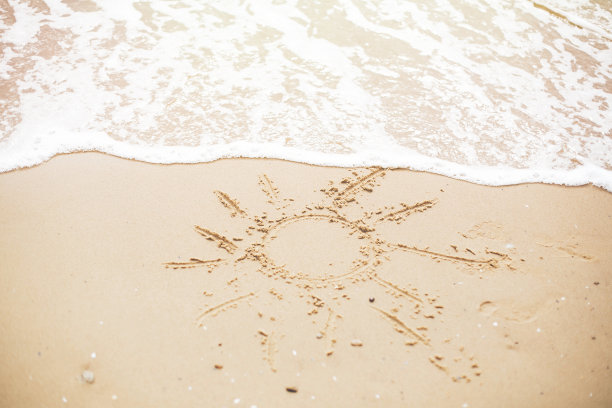 海滩上的太阳标志。夏日文字，阳光象征沙滩上的脚印和海浪的泡沫。你好,夏天的概念。度假、放松和旅行。本空间图片下载