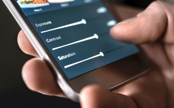 用手机和智能应用程序编辑照片。男人调整滑块。图像编辑，操作，改进或增强与智能手机。图片下载