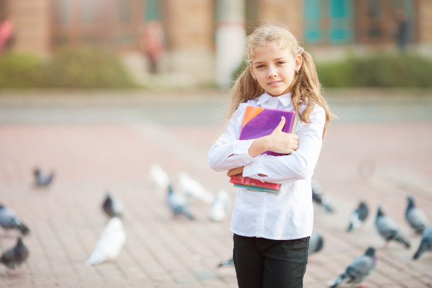 背着书包和书在户外的女学生。教育与学习理念。图片下载