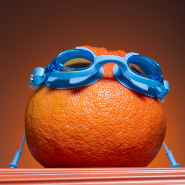 大柚子或橙色在蓝色游泳眼镜上，在橙色的背景上，度假的概念图片下载