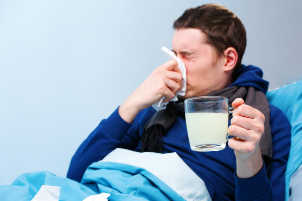 病床上戴着围巾，拿着一杯药的病人照片图片下载