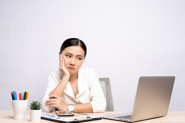 无聊的女人在办公室工作与笔记本电脑孤立的背景图片下载