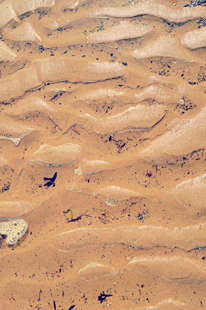 这是一张带有天然凹槽和卵石的湿沙的垂直照片图片下载