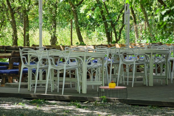 许多白色的桌子和椅子站在街上的人行道上图片下载