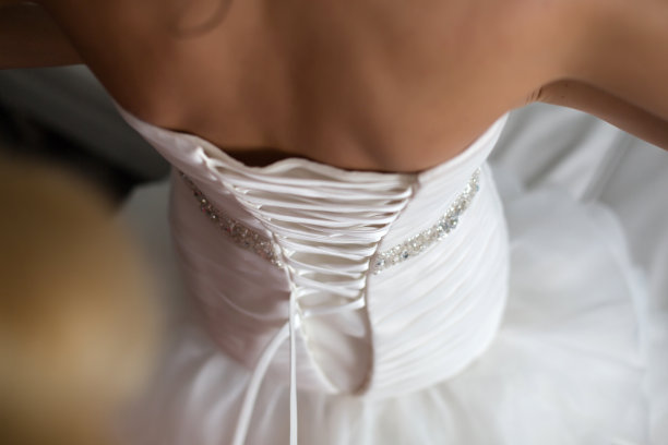 给婚纱镶花边。图片下载