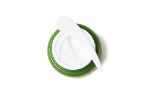 绿色的罐与白色奶油和塑料抹刀在白色背景，俯视图图片下载