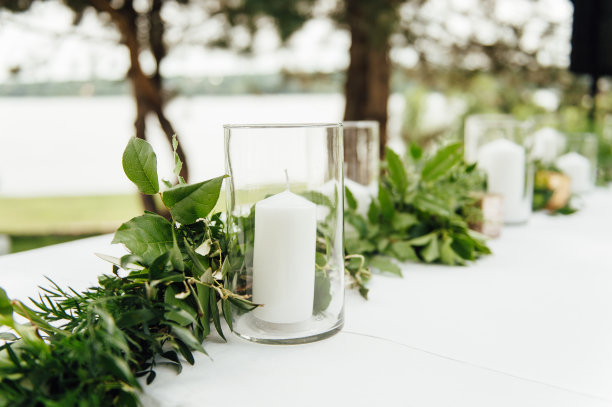 表装饰婚礼。桌上的花瓶、玻璃杯和礼品盒里放着一束美丽的鲜花。图片下载